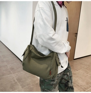 Vue détaillée du sac bandoulière en toile vert militaire de style utilitaire avec poche