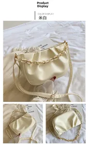 Detail of creamy white pleated cloud bag with chunky chain and matte leather texture