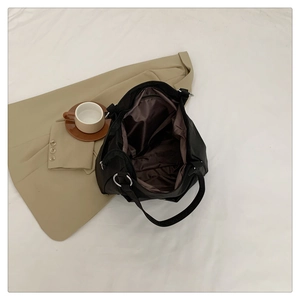Detailed interior of black nylon tote bag showing dark lining and silver metal ring hardware