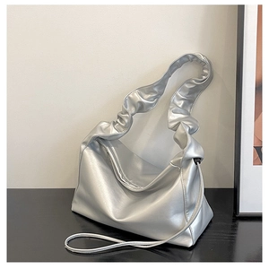 Detail of the silver metallic shoulder bag featuring pleated edges and artistic design