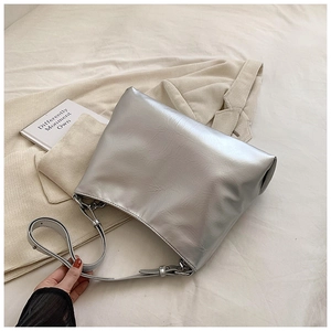 Detailed macro of the silver tote bag showing crinkled faux leather and metal chain links