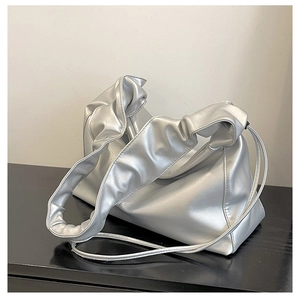Detail of metallic silver pleated cloud bag with stylish ruched texture on shoulder strap