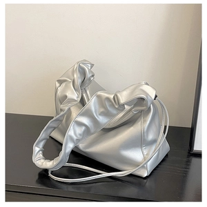 Detail of silver pleated cloud bag with metallic finish and sculptural handle