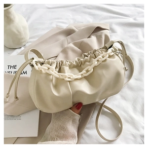 Détail du sac nuage plissé beige avec chaîne en acrylique et bandoulière en cuir