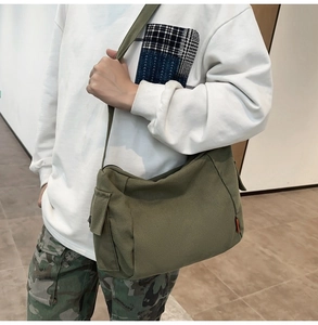 Vue détaillée du sac bandoulière en toile vert armée avec poche latérale et fermeture éclair