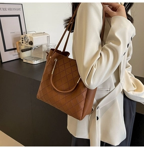 Detailed view of brown lychee leather tote bag with elegant diamond quilted stitching