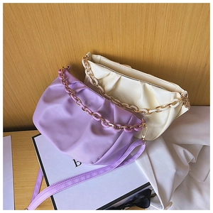Detail of lavender and cream pleated cloud bags with decorative chain and soft leather texture