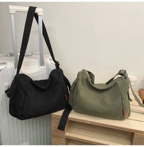 Détail de sacs bandoulière en toile noir et olive avec bretelles réglables et poches côté