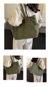 Detail of olive green corduroy tote bag showing front zip pocket and side compartments