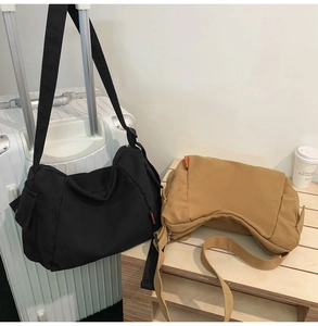 Détail de sacs bandoulière en toile kaki et noir avec larges sangles et poches latérales