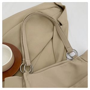 Detail of nylon tote bag shoulder strap with silver metal rings and contrast stitching