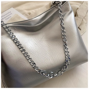 Close-up of metallic silver tote bag with natural pleated texture and chunky chain strap