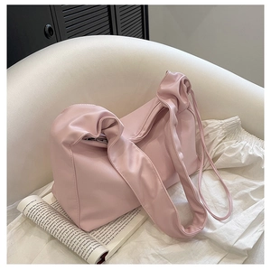 Close-up of soft pink PU leather baguette bag with a stylish knotted pleated shoulder strap