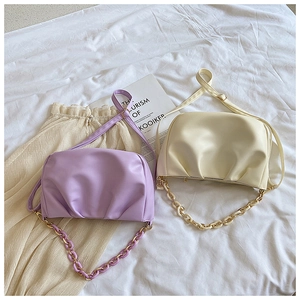 Detail of soft leather pleated cloud bags in lavender and off-white with resin chains