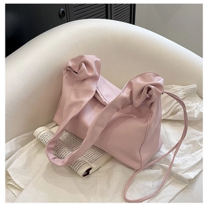 Detail of light pink baguette bag showing scrunchie shoulder strap and soft PU leather