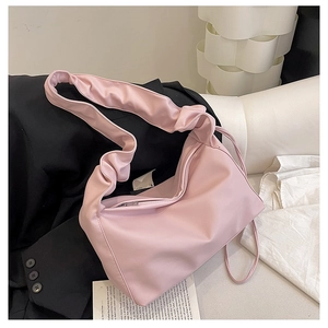 Detail of light pink baguette bag with stylish pleated cloud shoulder strap design