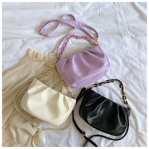 Detailed close-up of pleated cloud bags in light purple, cream white, and black leather