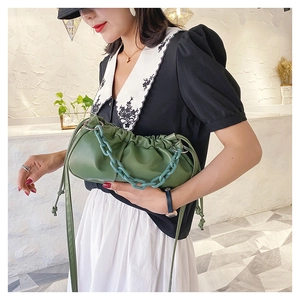 Détail d'un sac nuage plissé vert olive avec une grosse chaîne en acrylique tendance