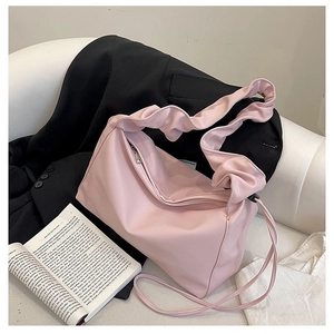 Detail shot of the pleated wide shoulder strap on this stylish pink baguette tote bag