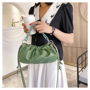 Gros plan du sac nuage vert olive plissé avec chaîne acrylique dans un décor de café