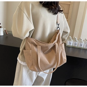 Detailed view of the khaki corduroy tote bag showing side pockets and adjustable strap