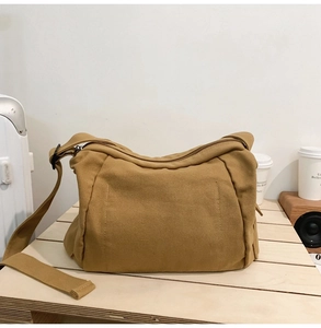 Détail du sac bandoulière en toile kaki avec sangle robuste et fermeture éclair