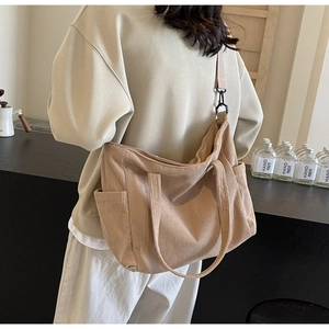 Detailed back view of a beige corduroy tote bag showing side pockets and adjustable strap