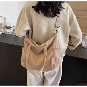 Detail of khaki corduroy tote bag showing side pockets and adjustable shoulder strap