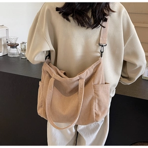 Detailed view of the beige corduroy tote bag showing the soft texture and side pocket