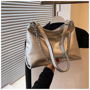 Detail view of silver metallic handbag featuring wrinkled texture and thick chain strap