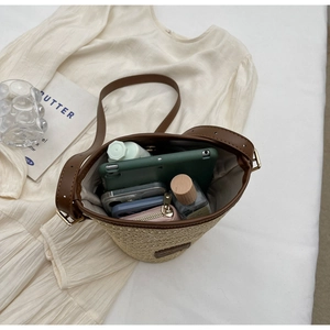Detail view of woven straw bucket bag showing internal capacity for daily essentials