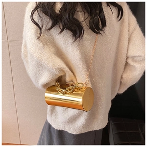 Detailed side view of golden cylindrical mirror clutch bag with chain handle for dinner wear