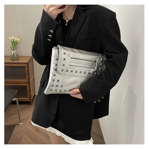 Pochette a busta argento moderna con borchie quadrate indossata con blazer nero