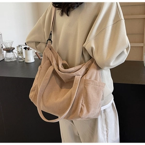 Detail of light brown corduroy tote bag showing striped texture and side pocket