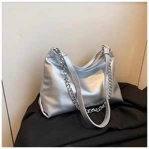 Macro detail of silver metallic textured faux leather bag with chunky chain strap