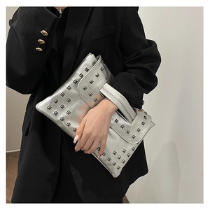 Dettaglio della borsa a mano argento con borchie quadrate e texture in ecopelle