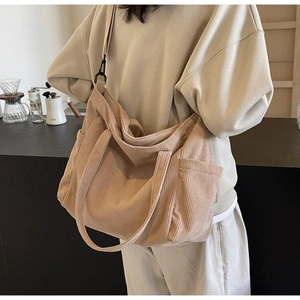 Detail view of khaki corduroy tote bag with side pocket and adjustable shoulder strap
