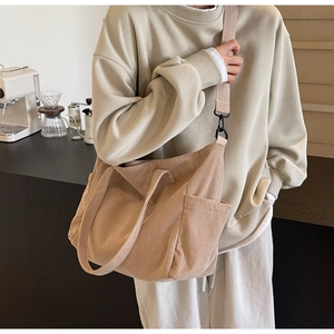 Detail view of the beige corduroy tote bag featuring a textured finish and metal hooks