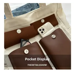 Detail view of canvas tote bag interior pockets for smartphone and glasses storage
