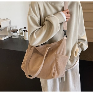 Close-up of beige corduroy tote bag showing textured fabric and adjustable strap