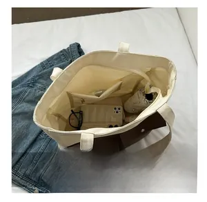 Interior of beige canvas tote bag showing large capacity for umbrella and phone