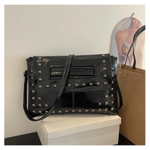 Dettaglio borsa in pelle lucida nera con borchie quadrate argento in stile punk