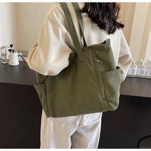 Detailed corduroy tote bag showing olive green texture and side pocket with zipper