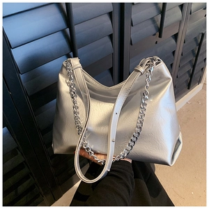 Detail of silver metallic tote bag with chain strap and pleated leather texture