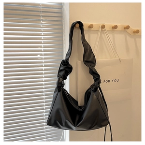 Detailed view of black hobo bag with unique ruched handle and textured PU leather