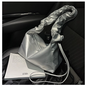 Detailed close-up of a silver metallic hobo bag with pleated handle and metal zipper