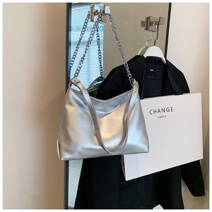 Detailed macro of silver metallic hobo bag with sleek chain strap and soft leather finish