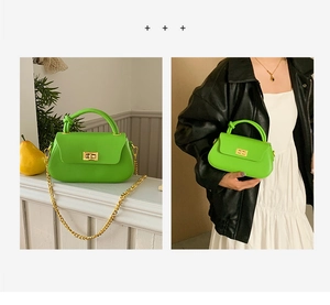 Detail view of neon green crossbody bag with knotted handle and golden chain strap