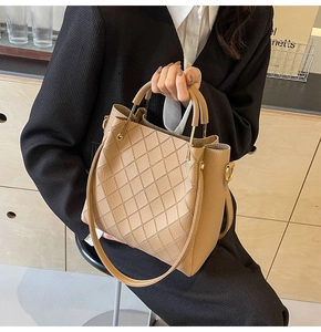 Detail of light brown lychee grain leather handbag with elegant diamond quilted stitching