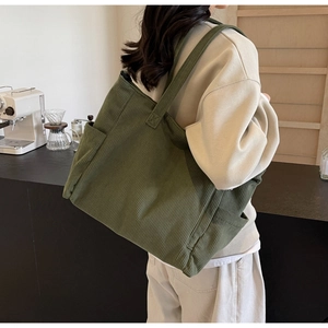 Side view of green corduroy tote bag showing textured material and side pocket